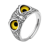 Silver ring with yellow eye-like stones on a white background